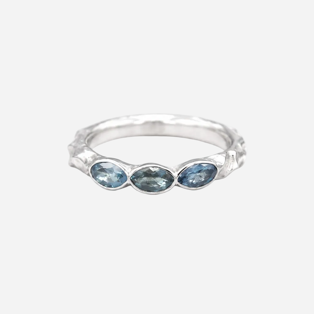 Silver ring with three blue gemstones on a white background