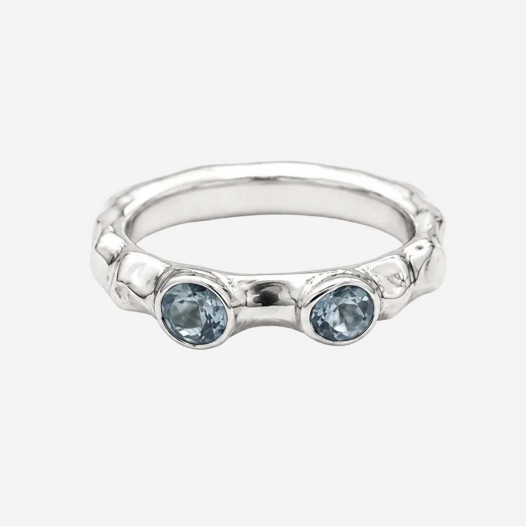 Silver ring with two blue gemstones on a white background