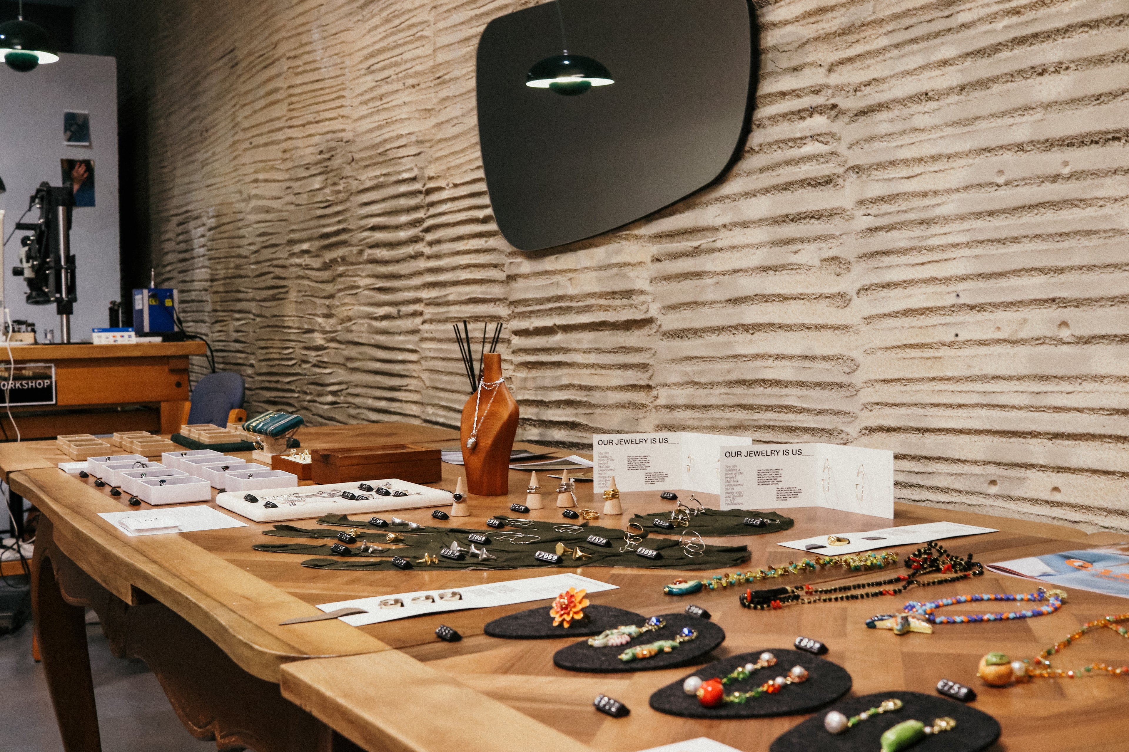 Table displaying various jewelry items against a textured wall.
