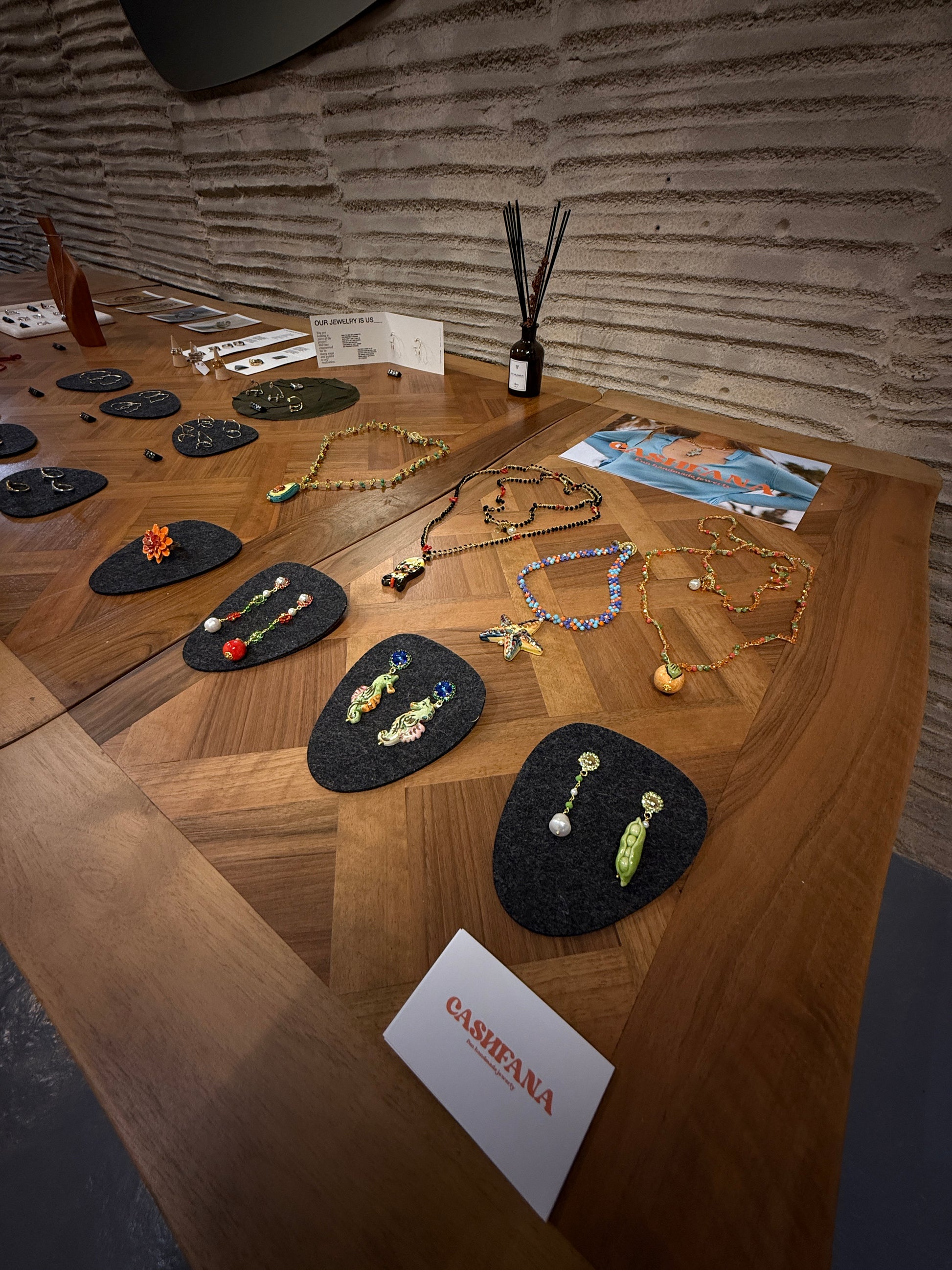 Jewelry displayed on a wooden table with a Cashfana card.