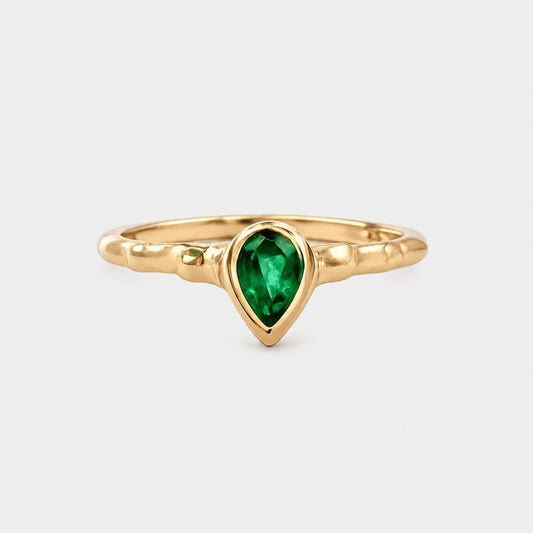Gold ring with a green gemstone on a white background