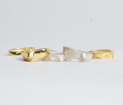 Three gold and silver rings on a light gray background