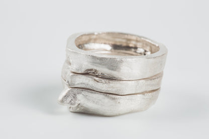 Silver ring with a textured design on a light gray background