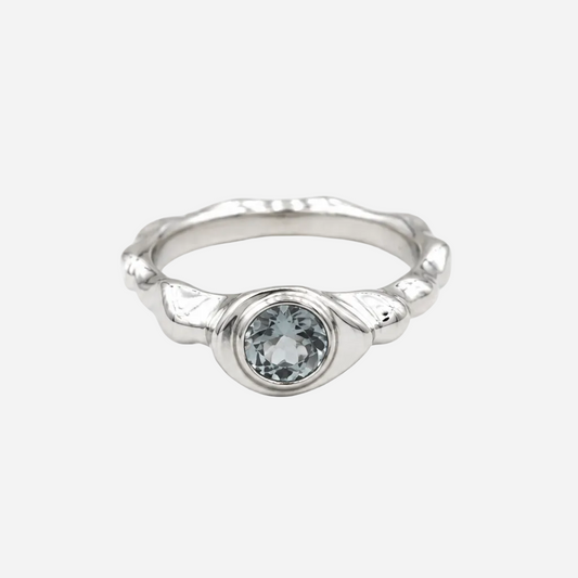 Silver ring with a clear gemstone on a white background