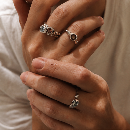 Close-up of hands with rings on fingers against a neutral background