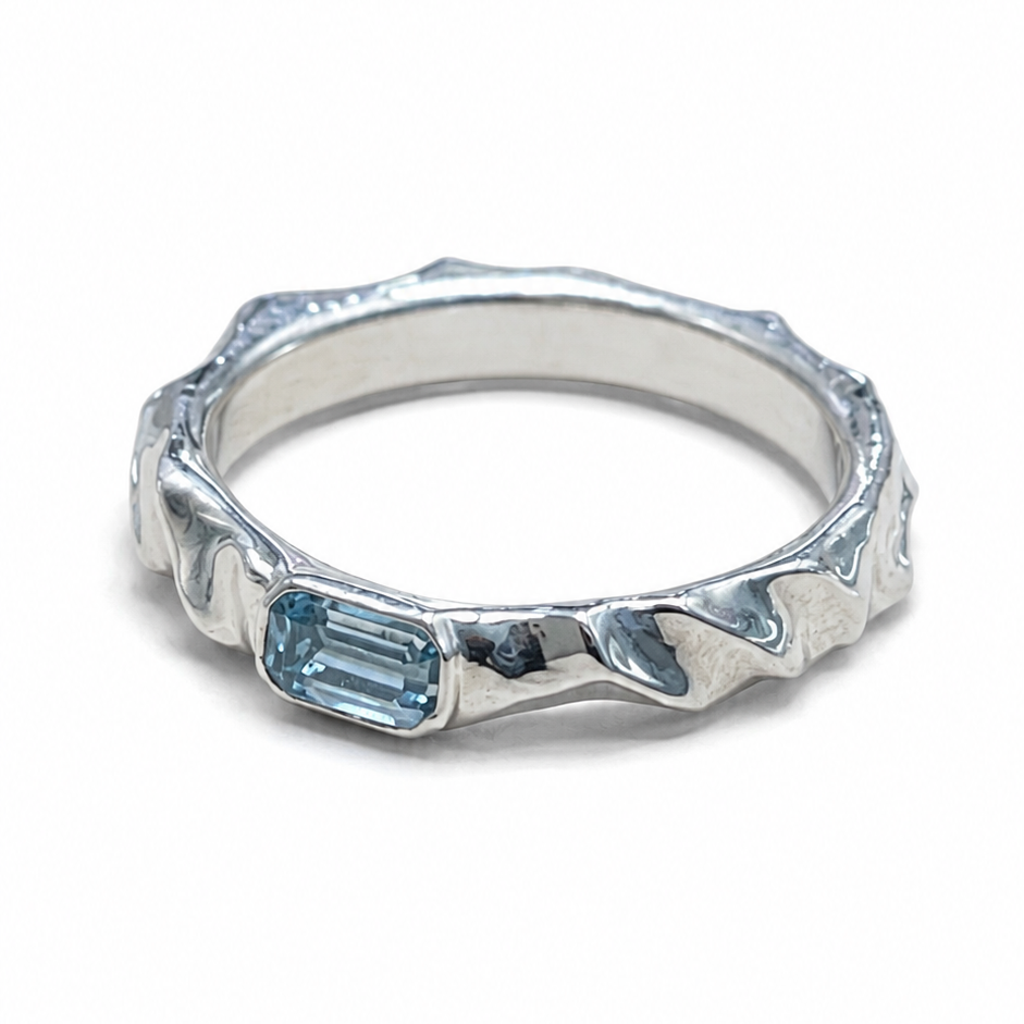 Silver ring with a blue gemstone on a white background