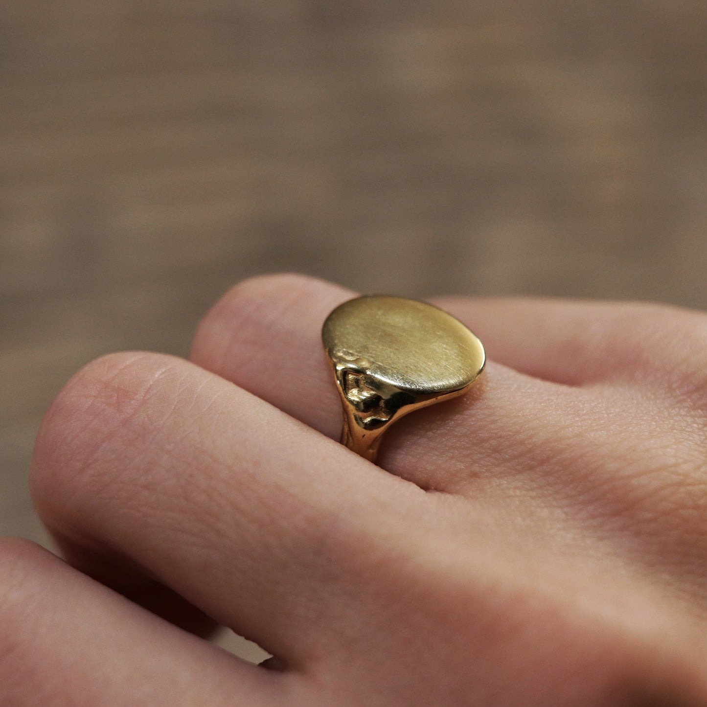Gold ring on a finger with a blurred background