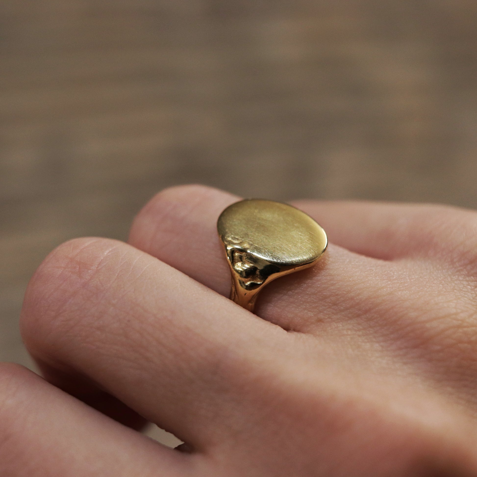 Gold ring on a finger with a blurred background
