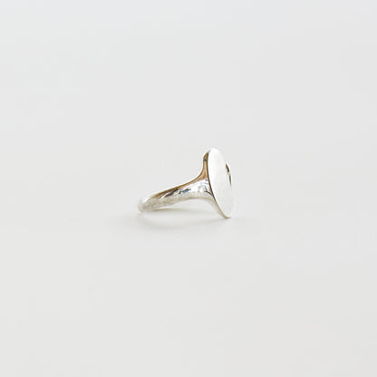 Silver ring on a light gray background