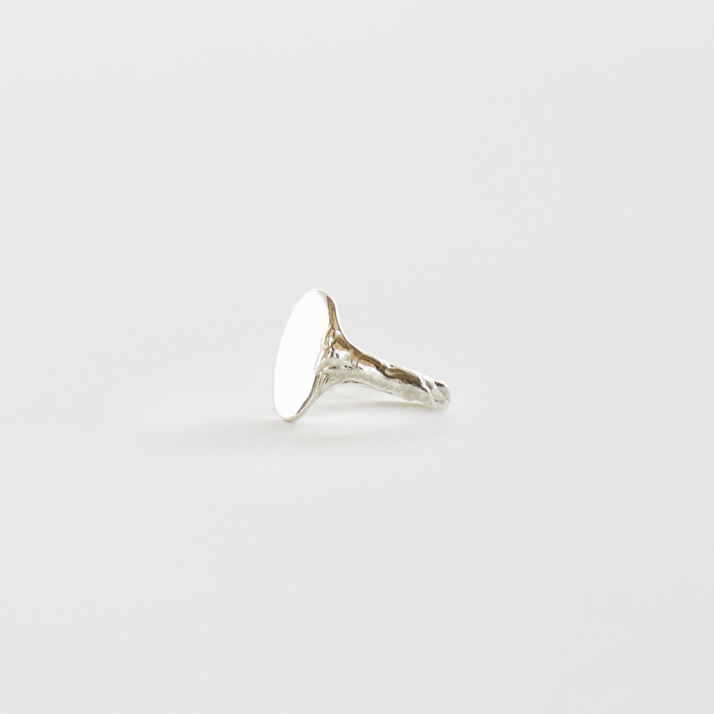 Silver ring on a light gray background