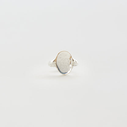 Silver ring with a textured band on a light gray background