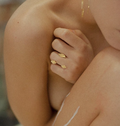Close-up of a person wearing gold rings on a blurred background