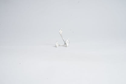Silver earring on a light gray background