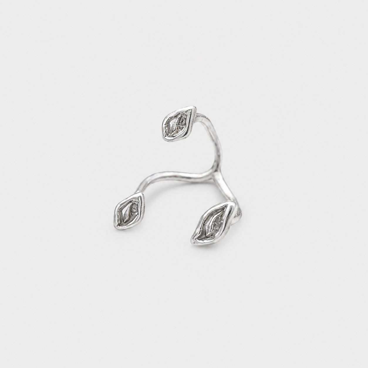 Silver ring with diamond-like stones on a light gray background