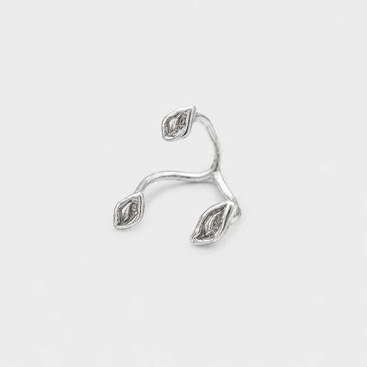 Silver ring with diamond-like stones on a light gray background
