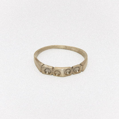 Silver ring with embedded stones on a light gray background
