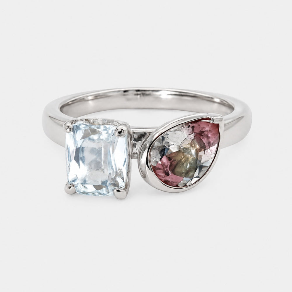 Silver ring with two gemstones on a white background