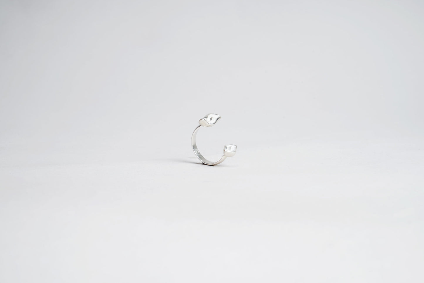 Silver ring with a small stone on a light gray background