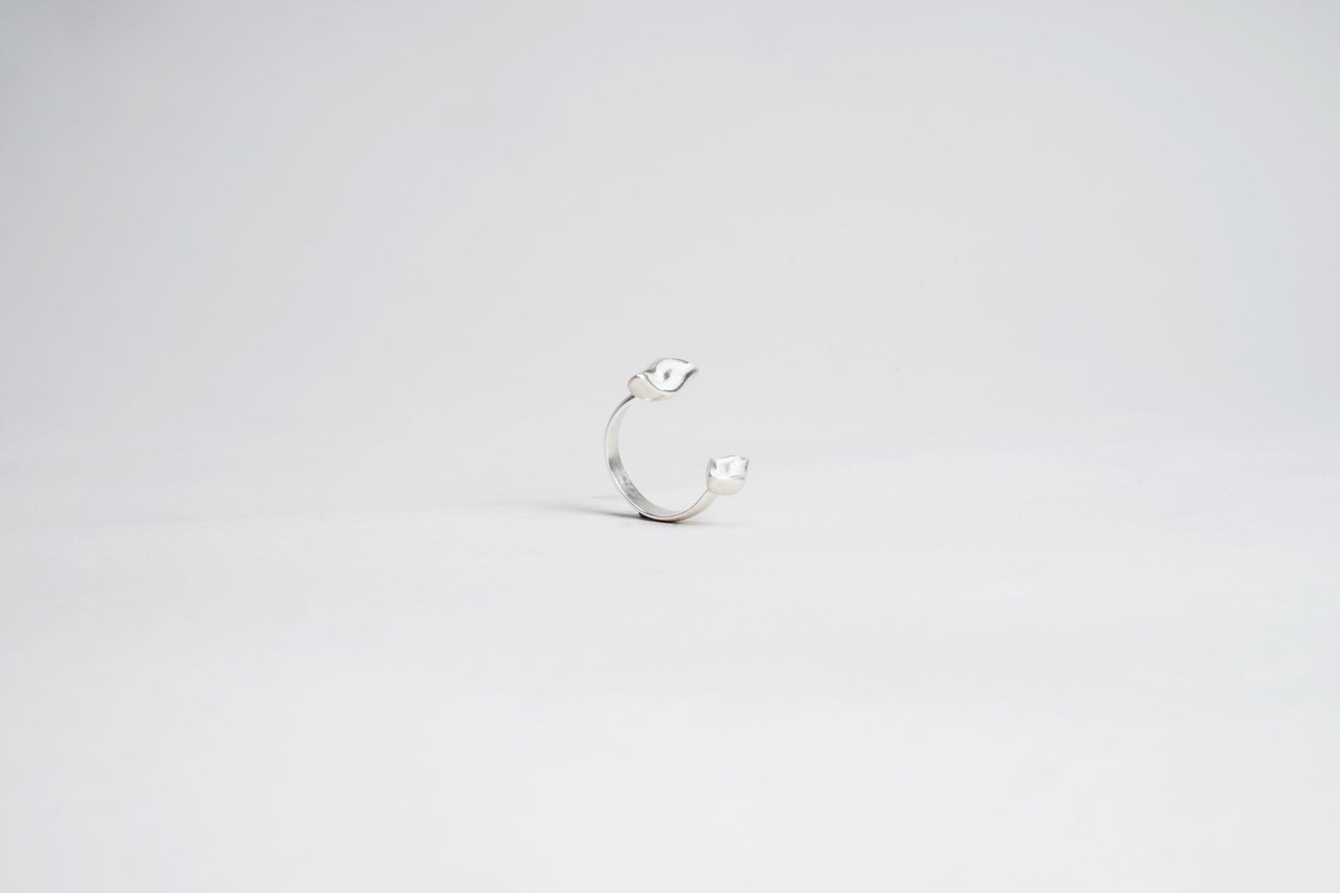 Silver ring with a small stone on a light gray background