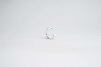 Silver ring with a small stone on a light gray background