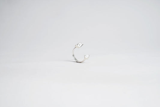 Silver ring with a small stone on a light gray background