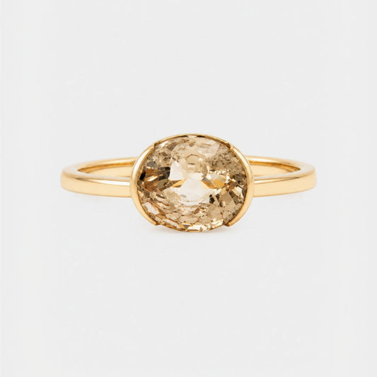 Gold ring with a large brown gemstone on a white background
