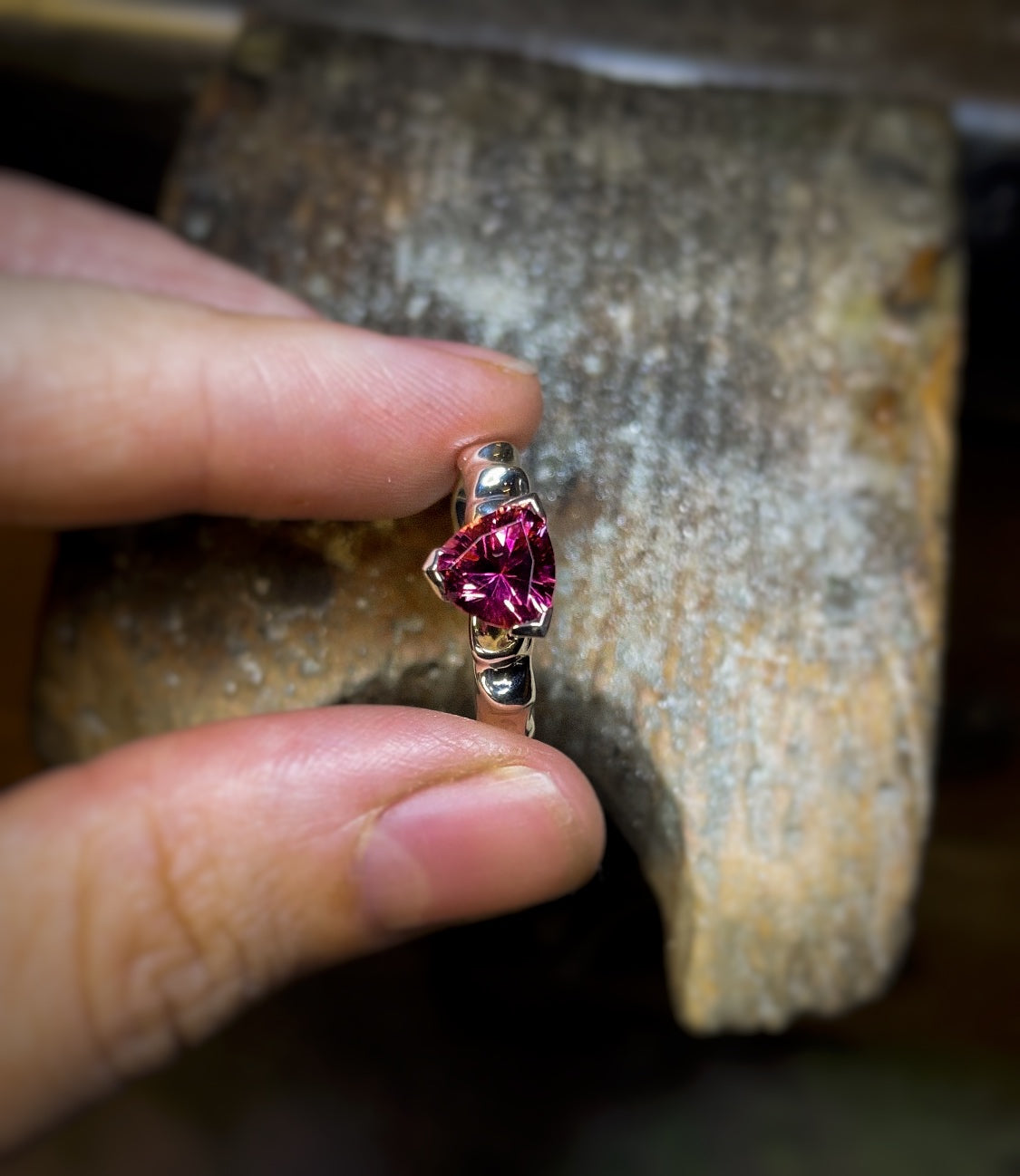 Rubellite ring held between fingers in the Dune Workshop atelier